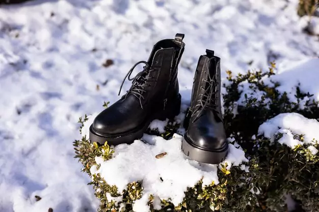 black-boots-snowy-grass-winter-black